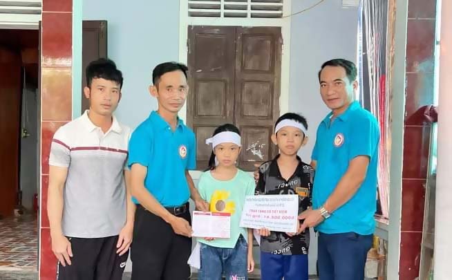 Anh Nguyễn Hữu Thái cùng các thành viên nhóm thiện nguyện Trái tim nhân ái Hưng Nguyên trao sổ tiết kiệm hỗ trợ 2 em nhỏ mồ côi. (NVCC)