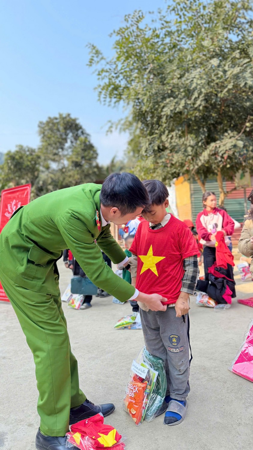  Ảnh 2: Anh Hoàng Xuân Hào trao quà và “Áo cờ Tổ quốc” cho các em